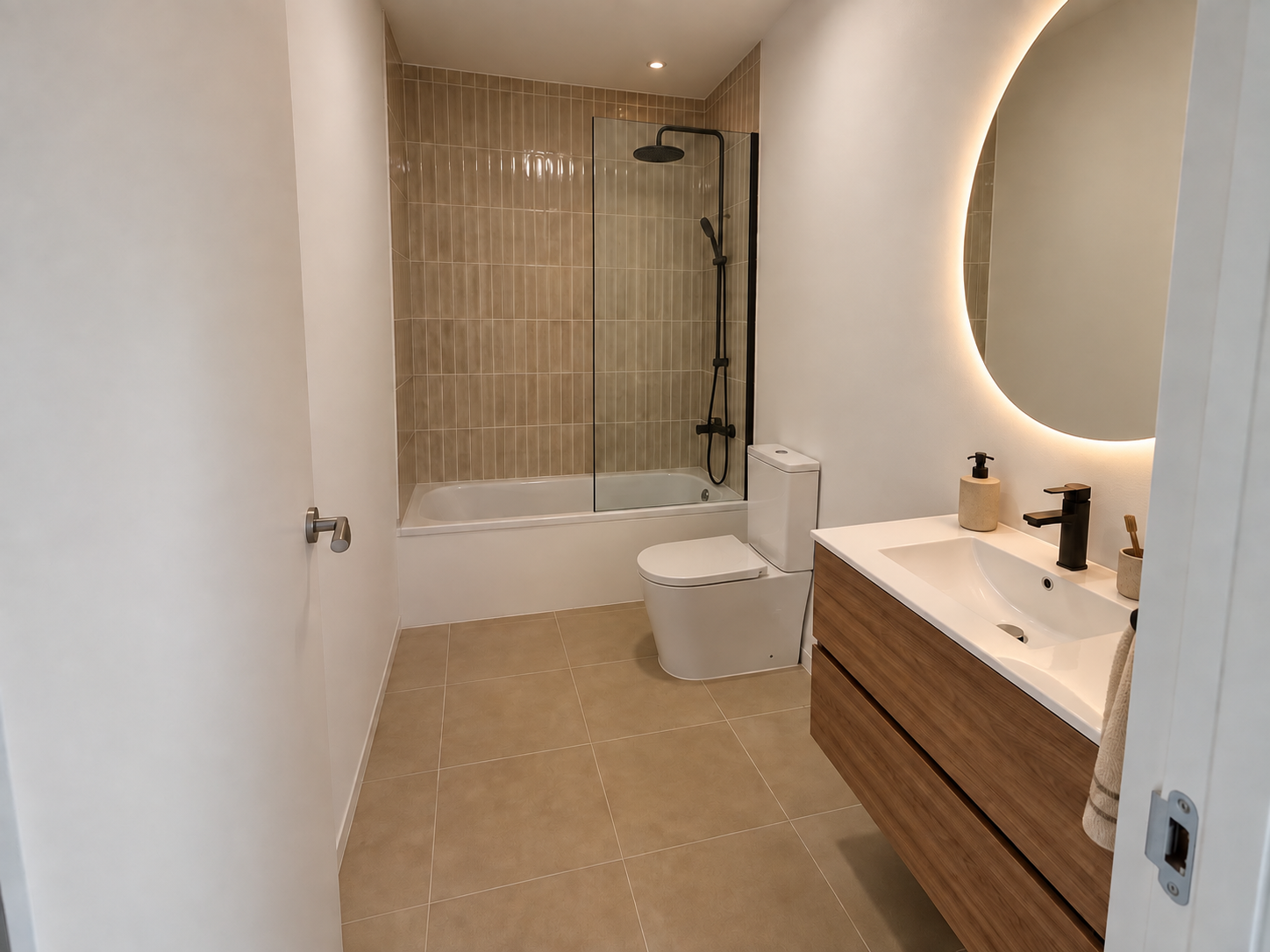 Baño con bañera, mampara y lavabo con espejo retroiluminado