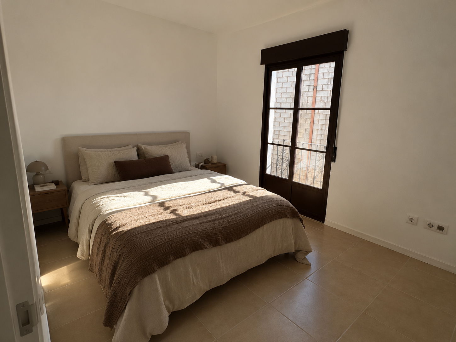 Dormitorio principal amueblado con cama de matrimonio y balcón