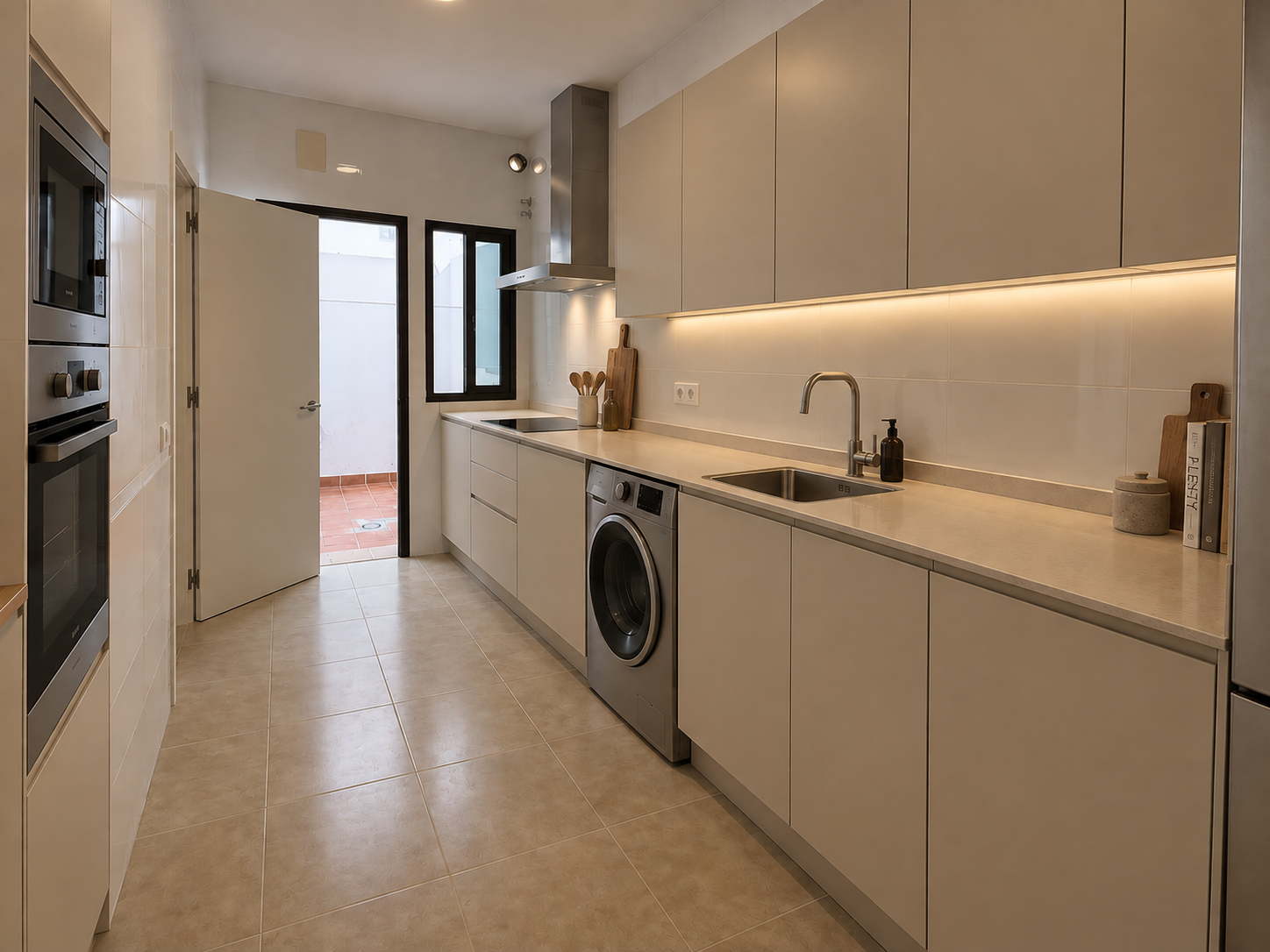 Cocina completamente equipada con encimera clara y electrodomésticos